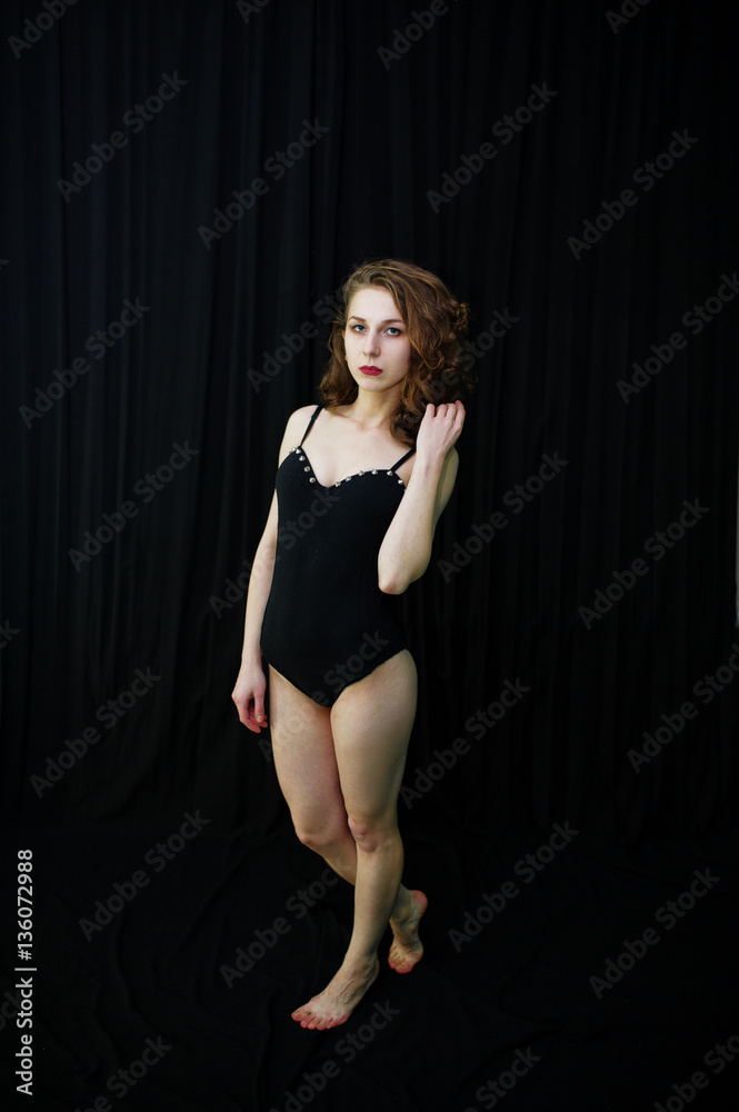 Girl dancer jumping and dancing on a black background. Studio sh