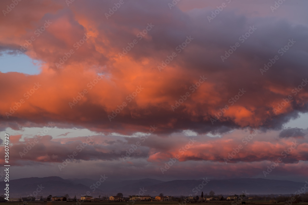 Obraz premium Glorious colorful sunset over the Tuscan countryside in the province of Pisa, overlooking the Tuscan Emilian Apennines, Italy