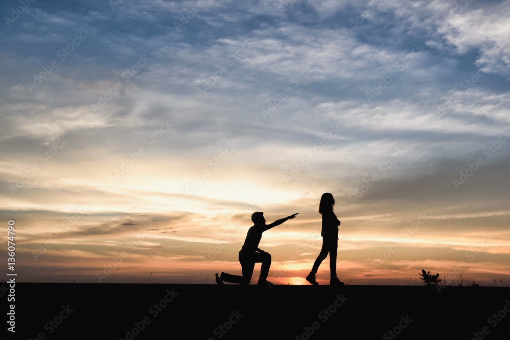 Silhouette of man and women are quarrel at sunset background.