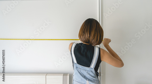 A woman measuring size of the room
