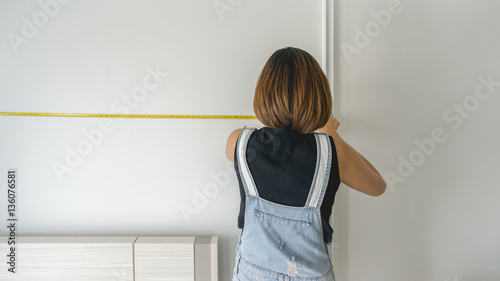 A woman measuring size of the room