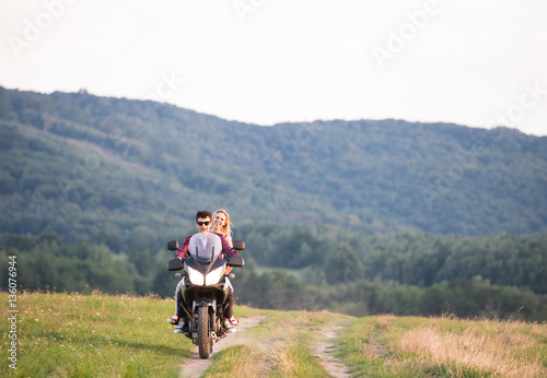 Couple in love enjoying a motorbike ride in countryside.