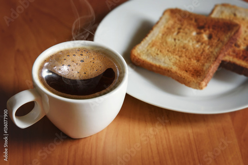 Hot black coffee in a white cup and fresh toast