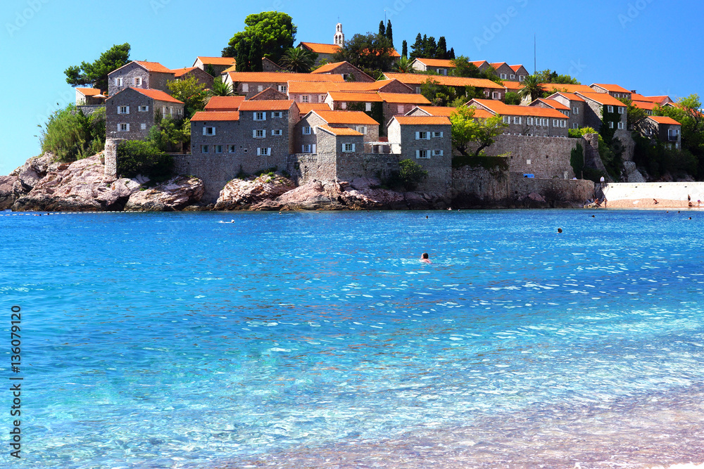 Montenegro's a major tourist attraction - the island of Sveti Stefan, the blue crystal clear sea, people swim
