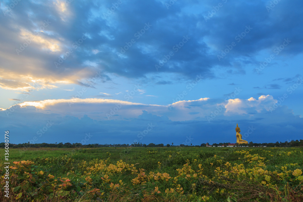Big golden buddha image at sunset background