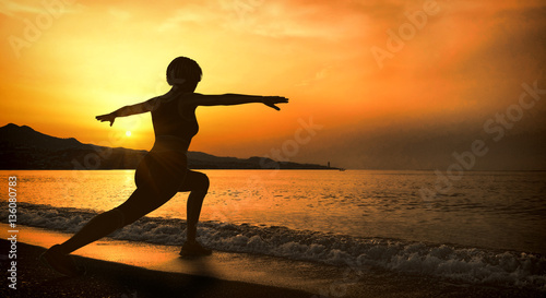 Girl doing yoga at sunset