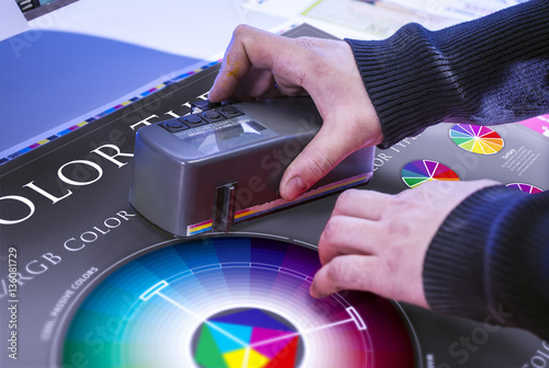 Young man in the process of offset printing and color correction