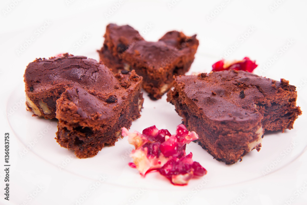 Heart shaped slices of a brownie decorated with pomegranate on white background Heart shaped slices of a brownie decorated with pomegranate on white background