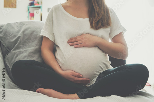 Fototapeta Pregnant woman touching her belly