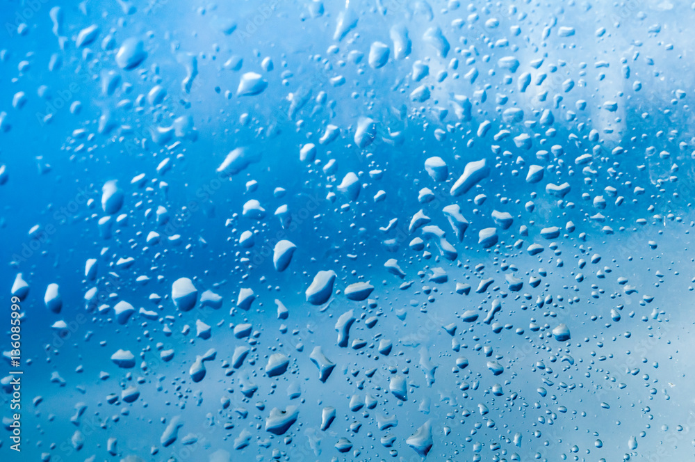 Several water drops on transparent glass and on blue background Several water drops on transparent glass and on blue background