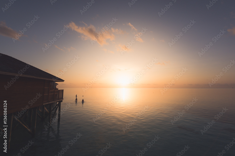 Silhouette beautiful tropical Maldives resort hotel and island with beach and sea on sunset sky for holiday vacation background concept - Boost up color Processing