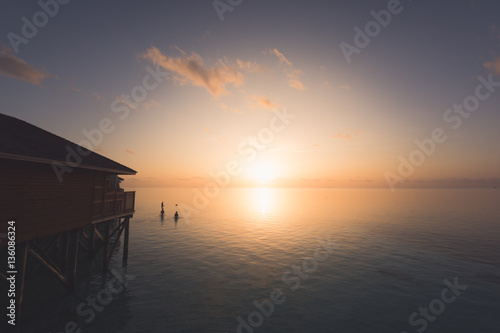 Silhouette beautiful tropical Maldives resort hotel and island with beach and sea on sunset sky for holiday vacation background concept - Boost up color Processing