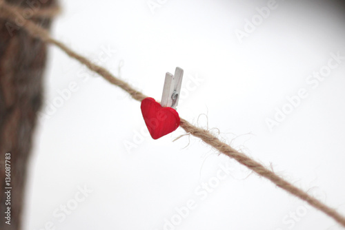 Rope with red Valentine's pinned heart. Valentine's Day background photo