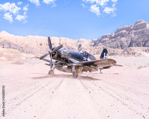 Fototapeta World war II military airplane taking off in the desert