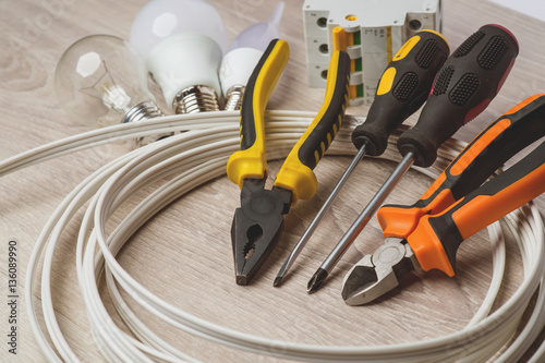set of electrician tools, a coil of wire and equipment in backgr