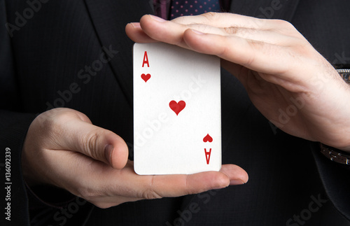 man holding a deck of cards and the ace of hearts