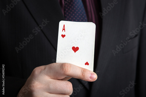 man holding a deck of cards and the ace of hearts
