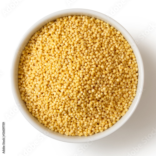 Dry millet in white ceramic bowl isolated on white from above. photo