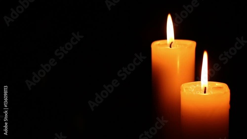 Quietly lit two candles. Bright light on dark background. RIP darkness template. Birthday party. Romantic evening on Valentine.