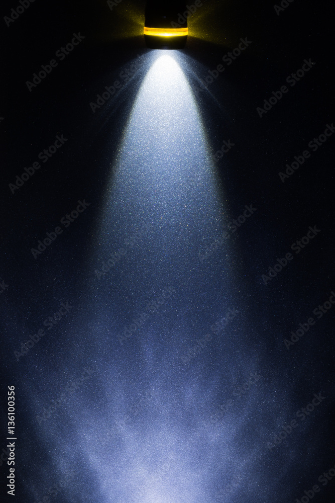 light beam, propagation of light from the LED flashlight on the metal surface painted in metallic color