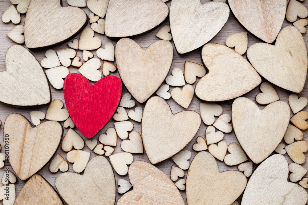 Obraz premium Wooden hearts, one red heart on the heart background.