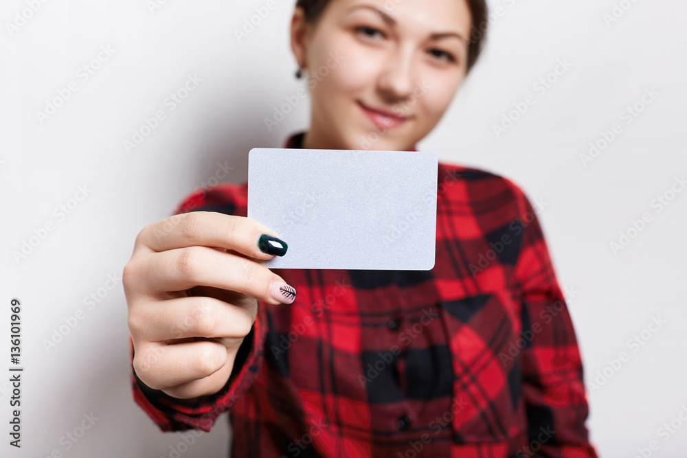 A woman with beautiful manicure, holding a blank business card with copy space for your promotional content. A stylish businesswoman in red shirt showing a parchment card at the camera A woman with beautiful manicure, holding a blank business card with copy space for your promotional content. A stylish businesswoman in red shirt showing a parchment card at the camera