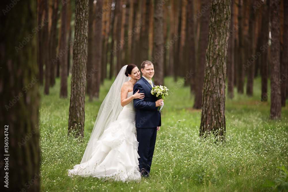 Beautiful bride in white wedding dress embrace groom in blue suit