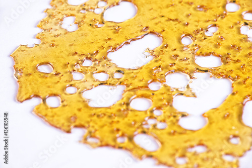 Piece of cannabis oil concentrate aka shatter isolated against w