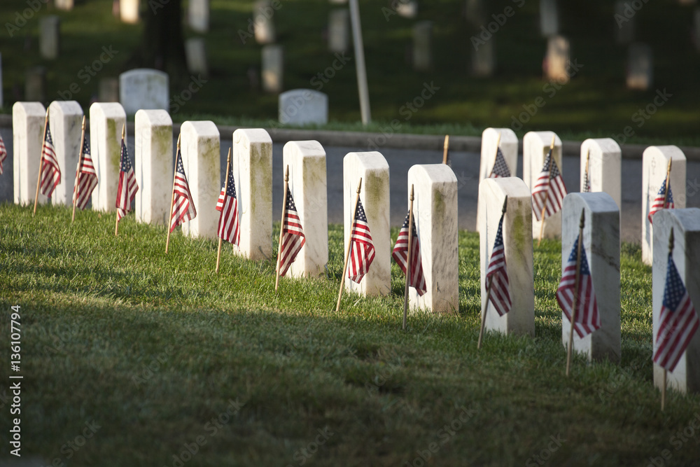 Naklejka premium Grave markers with flags at Arlington National Cemetery on Memor