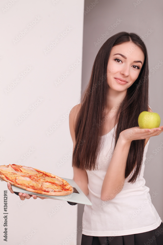 Diet. Young beautiful woman makes a choice between healthy lifestyle and harmful food. The concept of healthy eating and obesity. Beautiful slender figure girl Diet. Young beautiful woman makes a choice between healthy lifestyle and harmful food. The concept of healthy eating and obesity. Beautiful slender figure girl