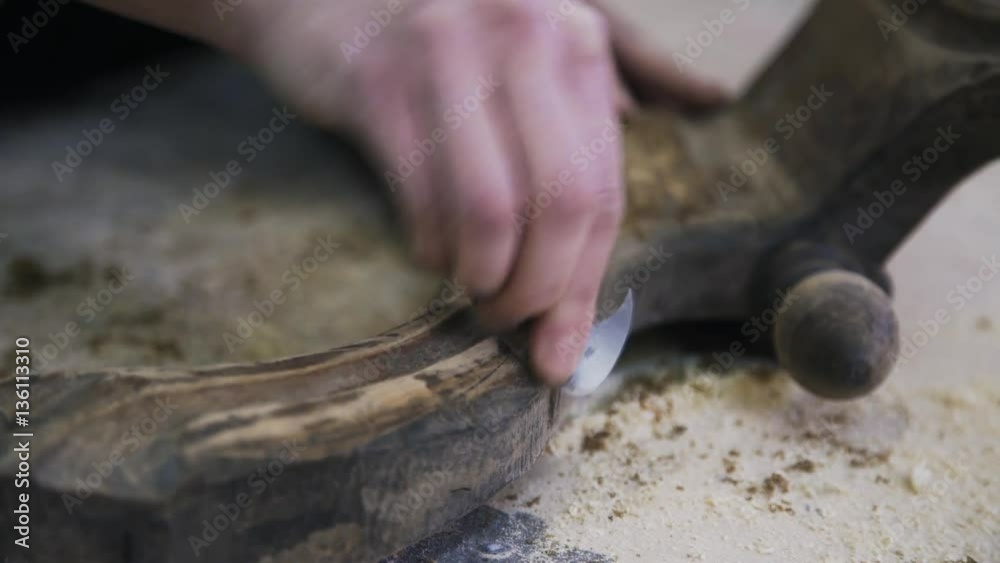 A young attractive carpenter is restoring the wood element of some furniture. Close up motion shot. A young attractive carpenter is restoring the wood element of some furniture. Close up motion shot.
