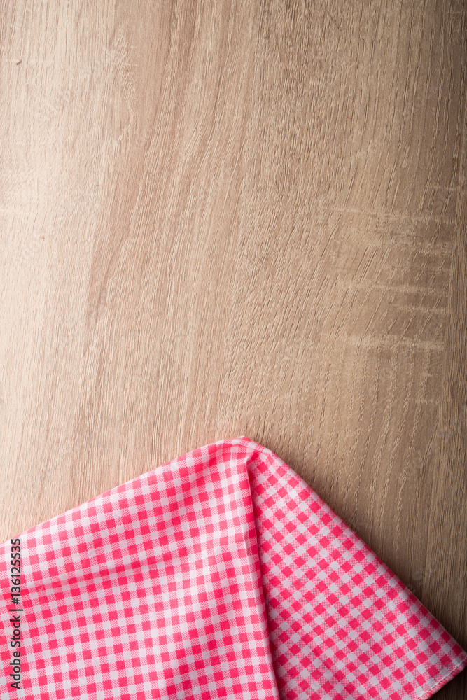 Checkered red and white napkin on wooden background. Checkered red and white napkin on wooden background.