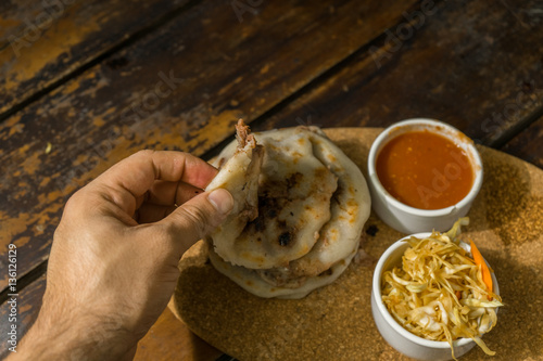 Salvadoran pupusas of beans and cheese on a plate accompanied by chirmol and tanning. photo