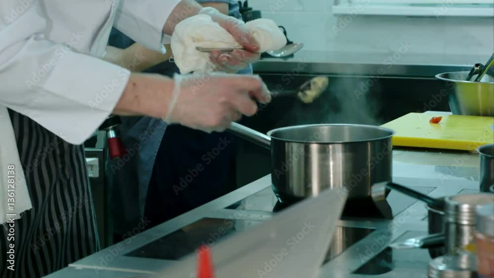 Experienced chef's male hands cooking meal on a stove Experienced chef's male hands cooking meal on a stove