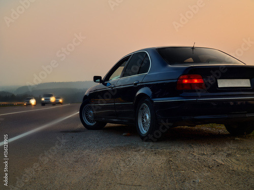 Автомобиль седан на трассе на фоне заката © Vadim Sofin