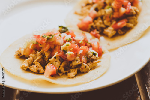 Tacos de carnitas y carne al pastor, comida Mexicana con tortillas.