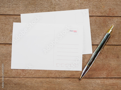 Top view blank of back postcard with pen on wooden background