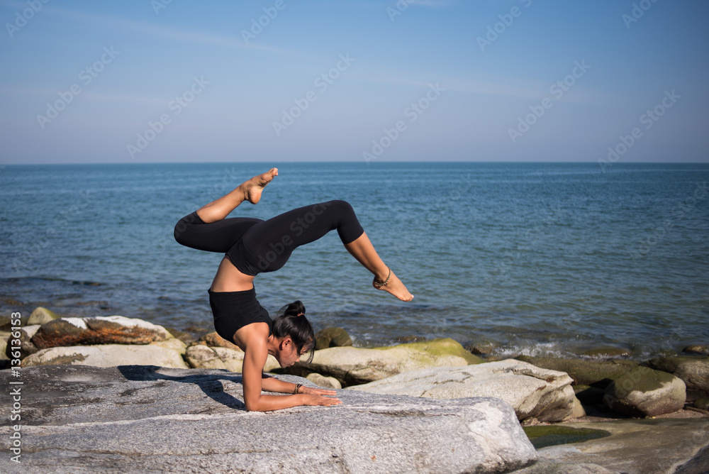 Asian woman practice yoga on the beach