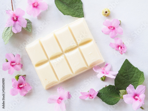 White chocolate dessert and pink floral softness on white background