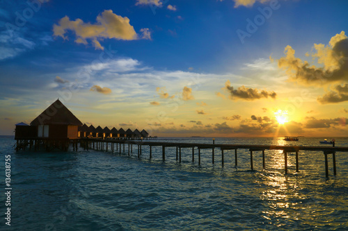 Beautiful sunset with water villas in tropical Maldives island..