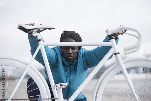 Portrait of young woman with white bicycle photo