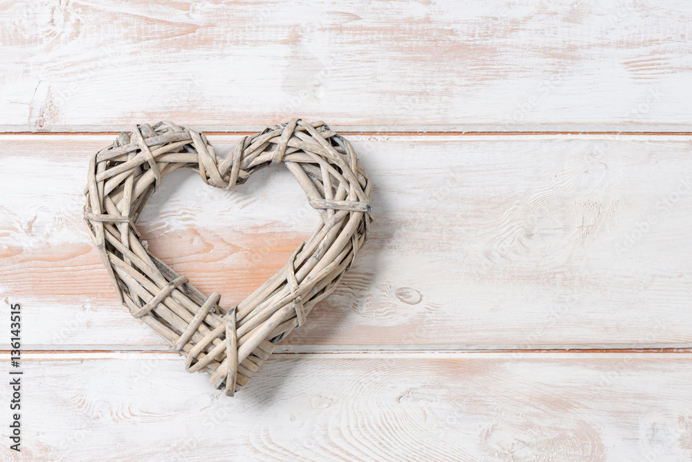 Fototapeta premium Wicker Rattan Heart on Wooden Panel with Copy Space