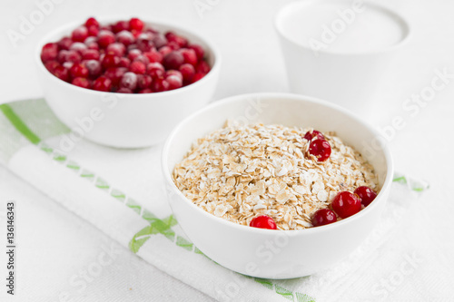 Rolled oats, porridge and cranberries for a healthy breakfast in a rustic style