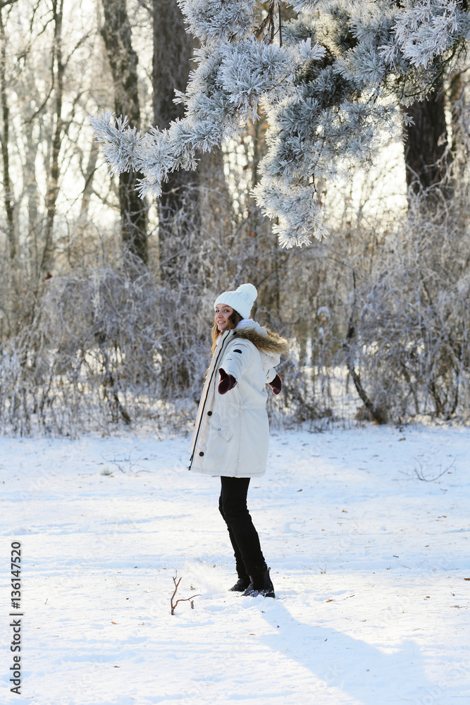 Obraz premium Woman in winter forest standing sideways to the camera