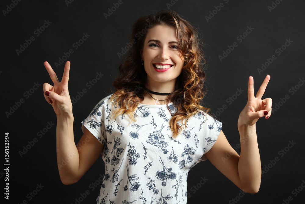 Beautiful girl model posing in a t-shirt on a black background. Beautiful girl model posing in a t-shirt on a black background.