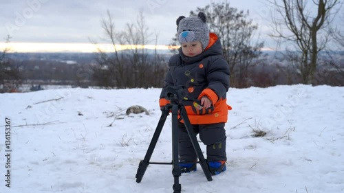 Cute kid playing with tripod