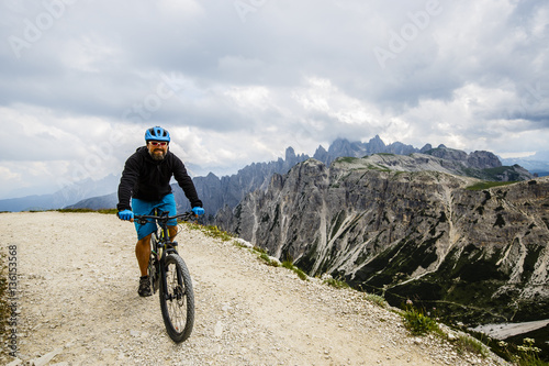Fototapeta Naklejka Na Ścianę i Meble -  View of cyclist riding mountain bike on trail in Dolomites,Tre C