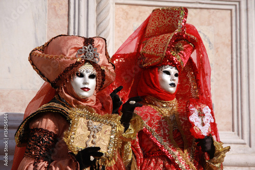 Women in colorful costumes and masks posing at the Venice carnival in Italy © Madeleine Steinbach