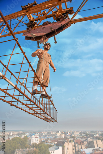 Bold builder standing on construction on high.