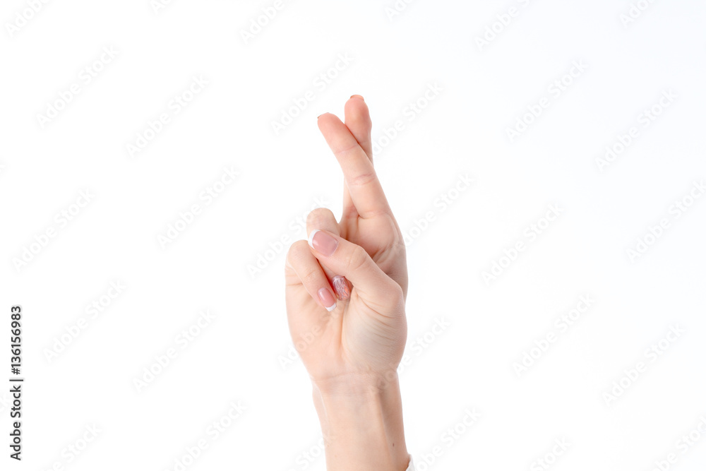 female hand showing the gesture with raised up and crossed two fingers is isolated on a white background female hand showing the gesture with raised up and crossed two fingers is isolated on a white background